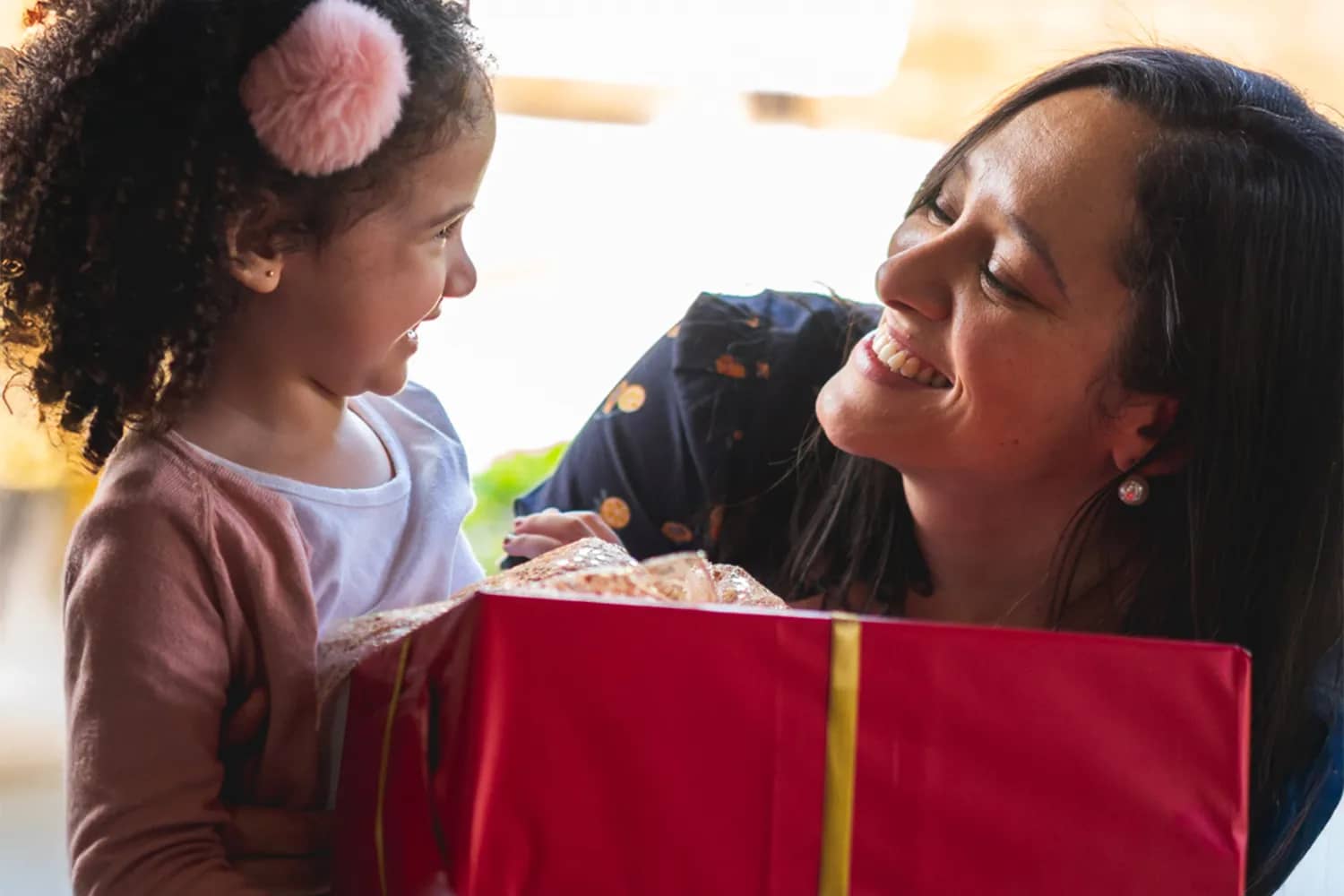 Young girl receives gift from mother